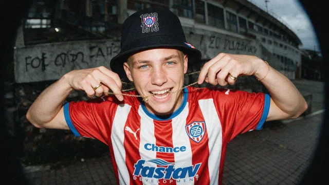 Fan in a Zbrojovka kit and bucket hat outside the stadium