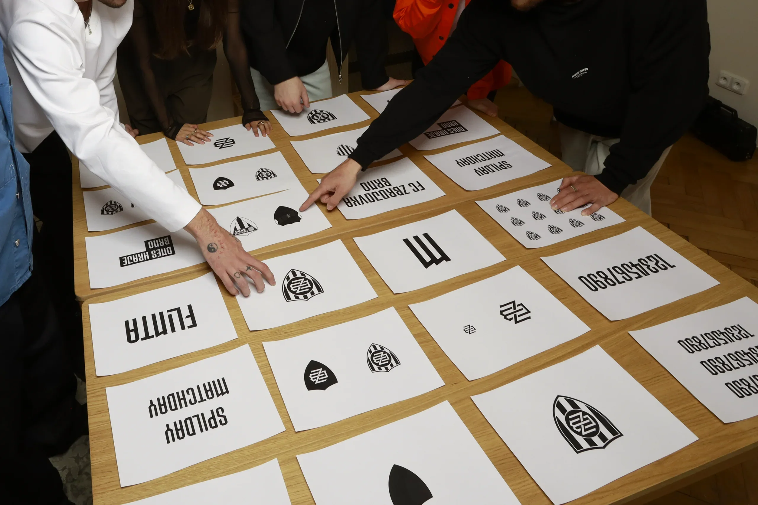 The team picking Zbrojovka crest sketches on a table