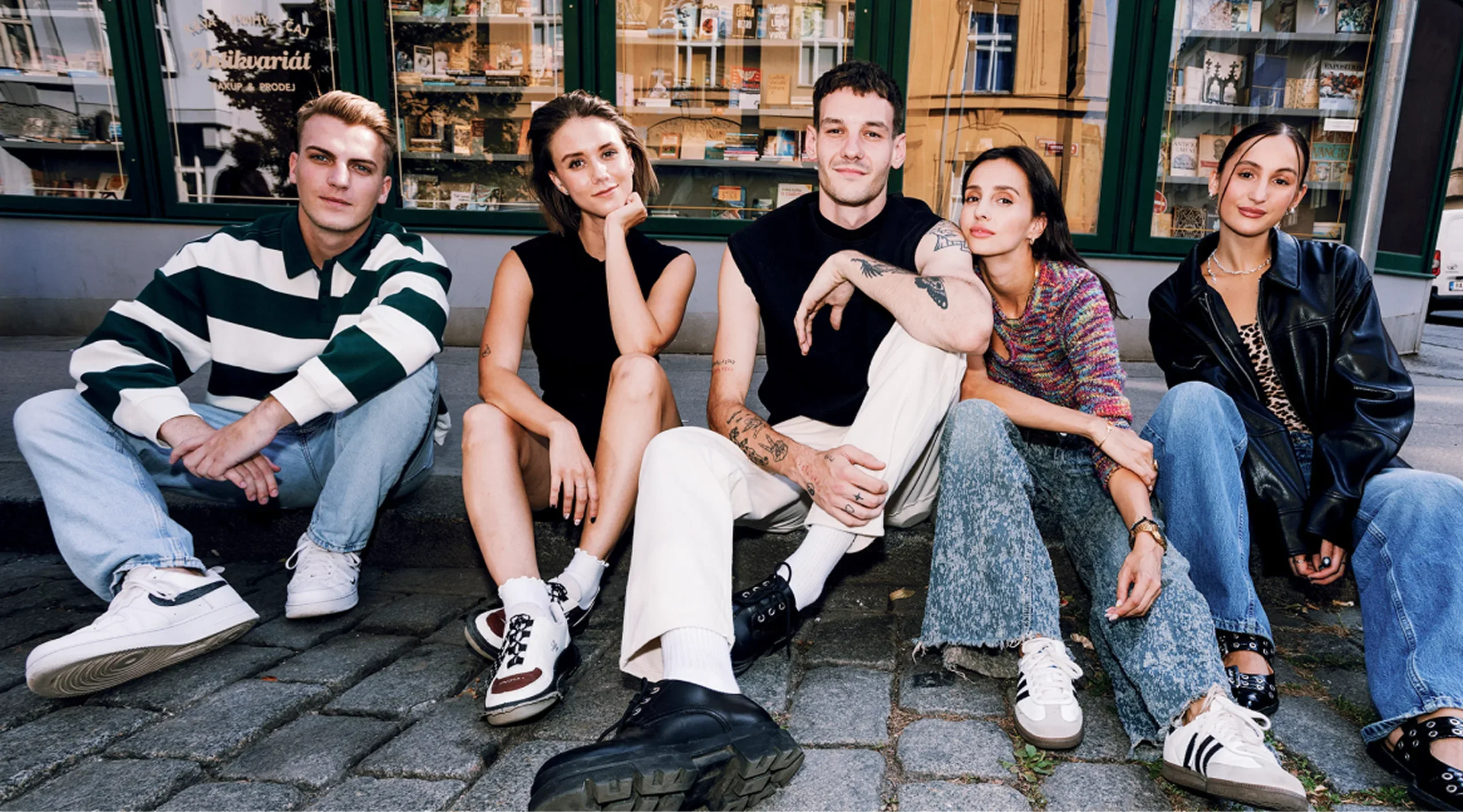 Boldie team sitting on the pavement outside a bookshop